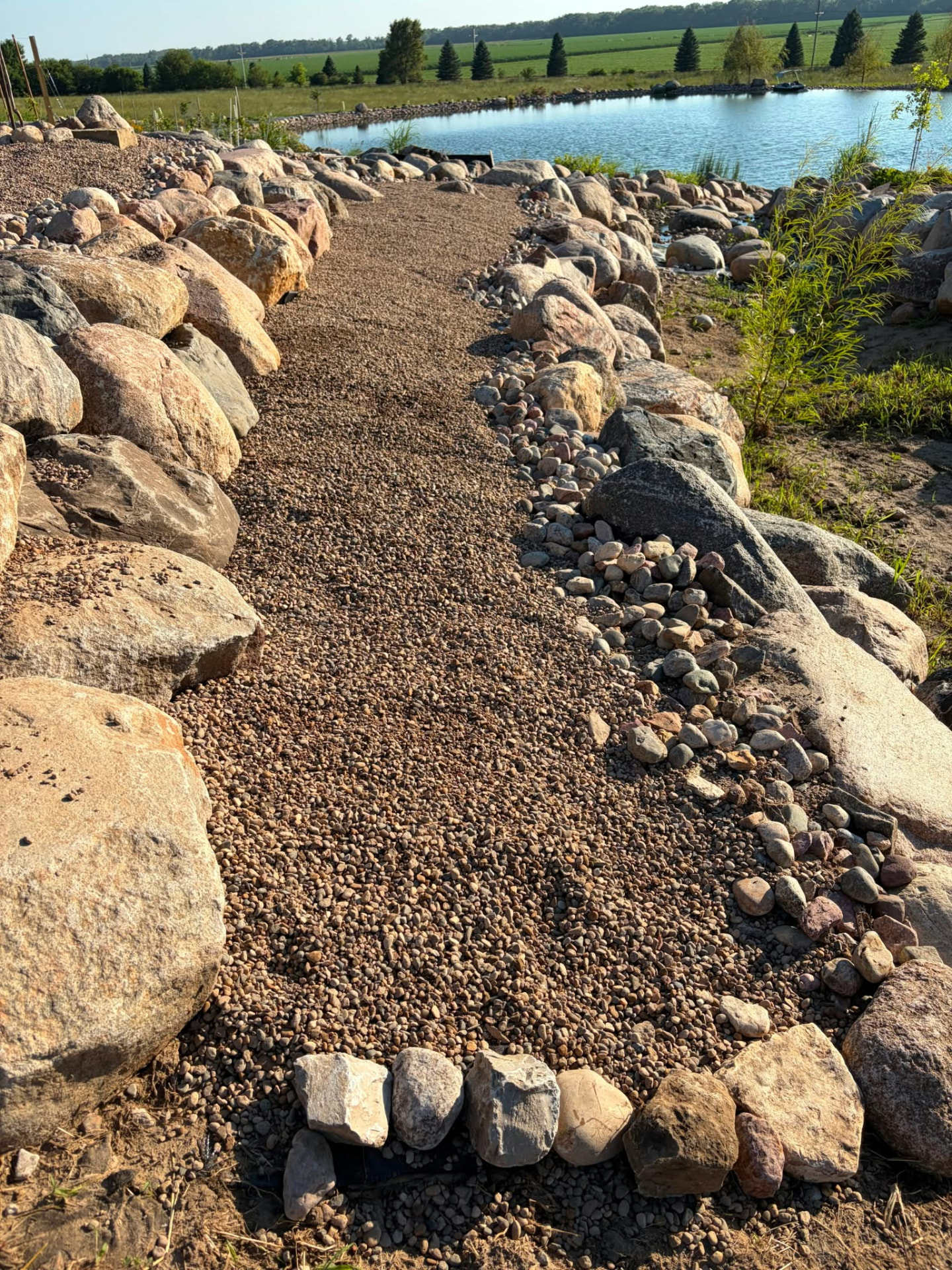 After: finished gravel path with stone edging along a backyard pond in Nebraska